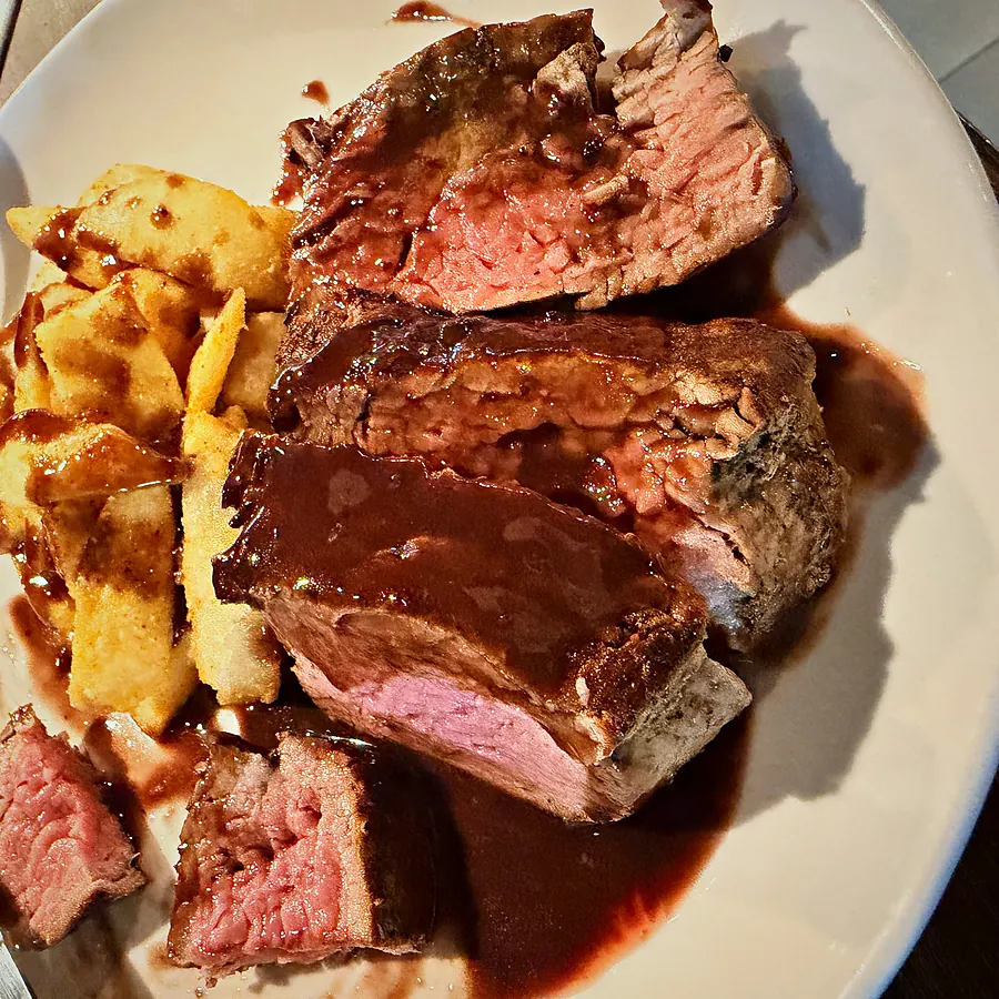 Sliced dry-aged steak with chips and red-wine jus